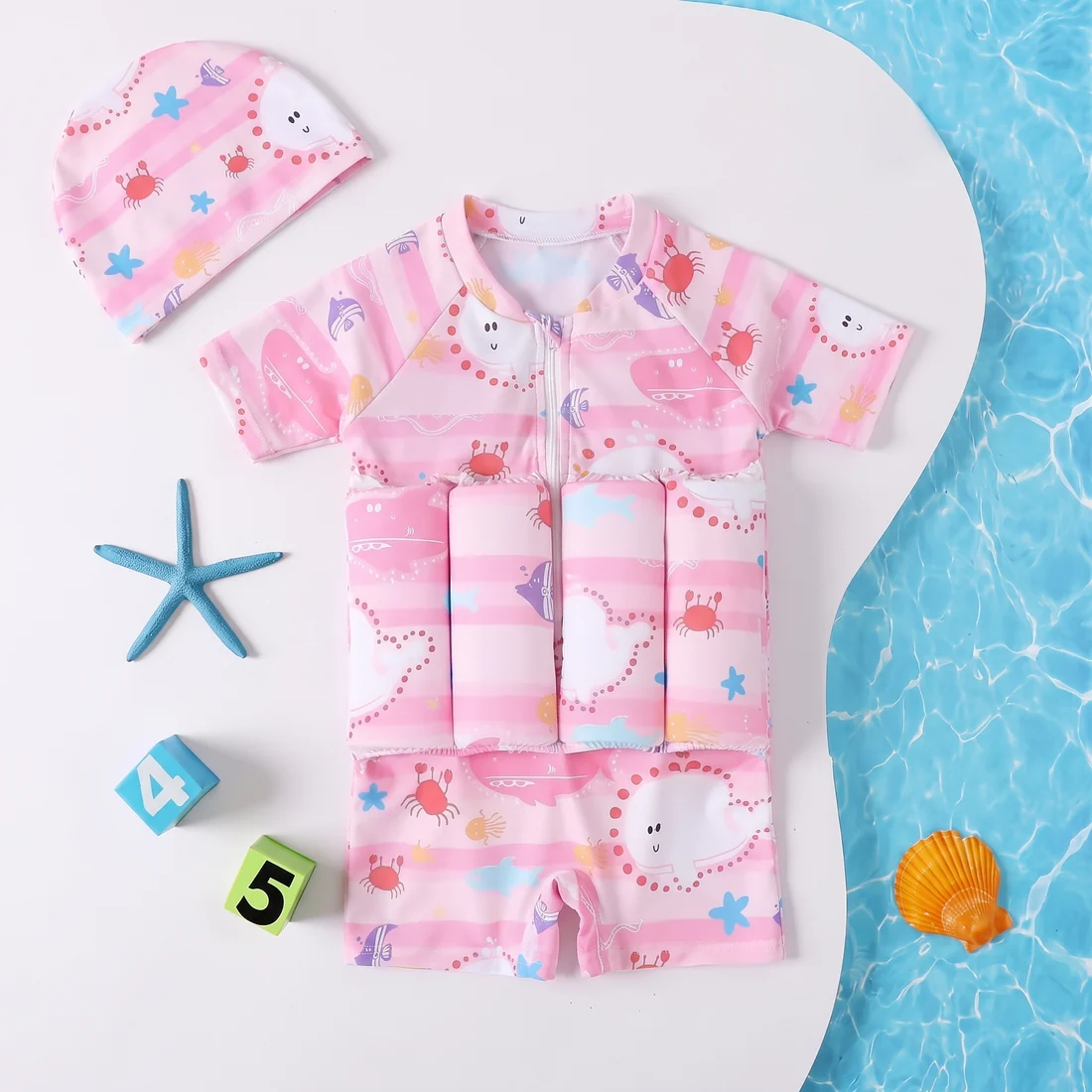 Child float suit in pink and white stripes with a sea-life print and matching swim cap