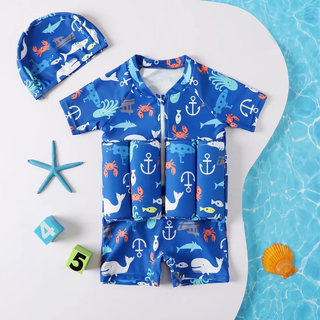 Child float suit in the blue nautical print with matching swim cap, starfish and shell props